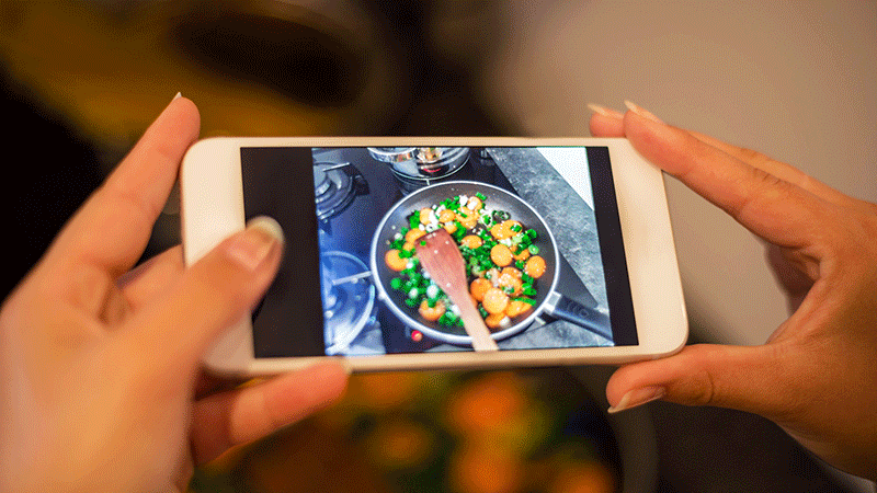 womans hands smart phone photographing food